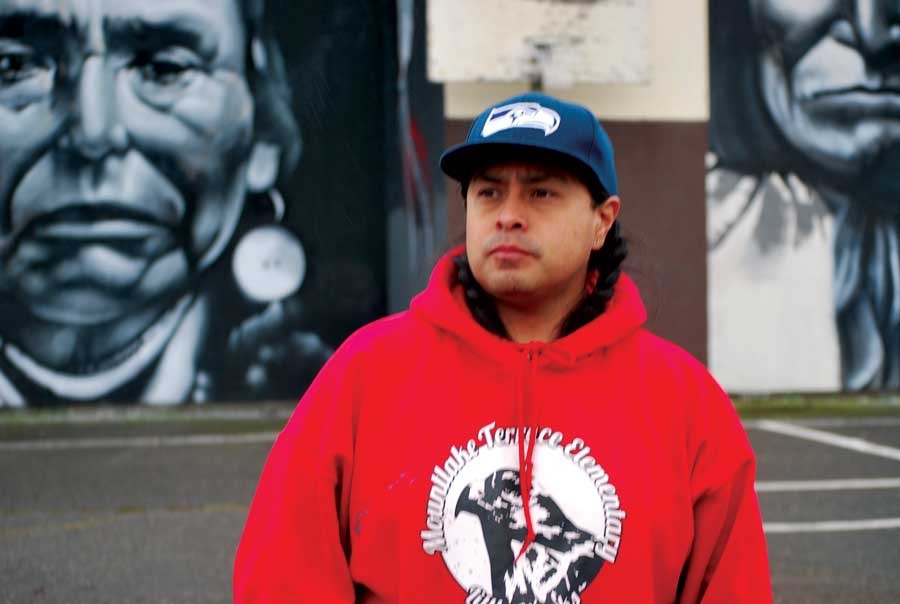 Artist Andrew Morrison stands before his newly cleaned murals which were vandalized on Sunday evening, , February 22. 