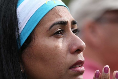 Silvina Rios, of Philadelphia, cries tears of joy as she watches the video monitor as Pope Francis arrives in Philadelphia on Saturday, Sept. 26, 2015. (David Maialetti/Philadelphia Inquirer/TNS)