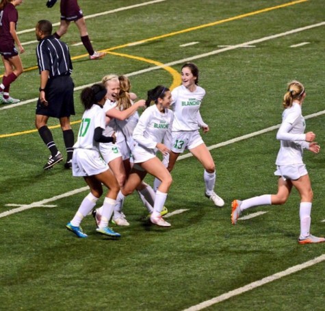 Brave teammates congratulating junior, Katie Newman, after scoring her first goal of the season while taking on Holy Names. 