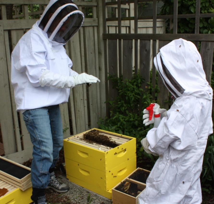 Ms. Armstrong and son, Drew, settling bees into new home from Southern California.