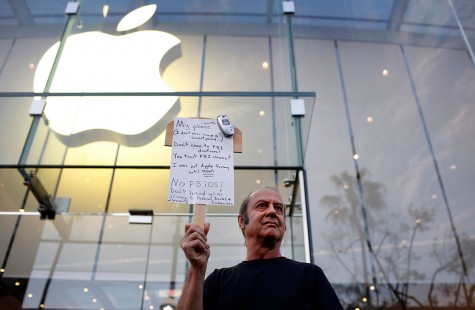 Tom Wolff holds a sign in support of Apple outside of the the Apple store in Santa Monica, Calif., on Tuesday, Feb. 23, 2016. Rallies were planned at Apple stores across the country to support the company's refusal to help the FBI access the cell phone of a gunman who took part in the killings of 14 people at the Inland Regional Center in San Bernardino. 