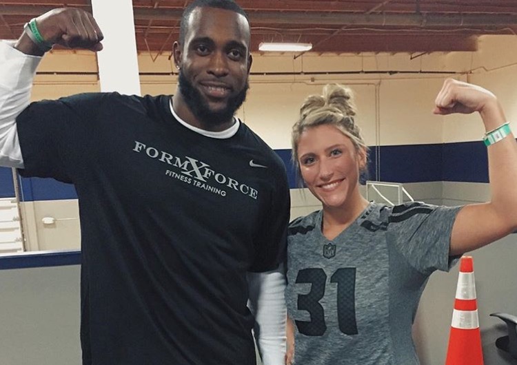 Kim Reese-White stands with Seahawk defensive player, Kam Chancellor, after a workout. 