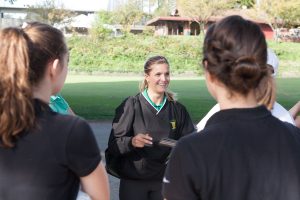 Ms. Comfort gives the girls golf team a pep talk before their final regular season match.