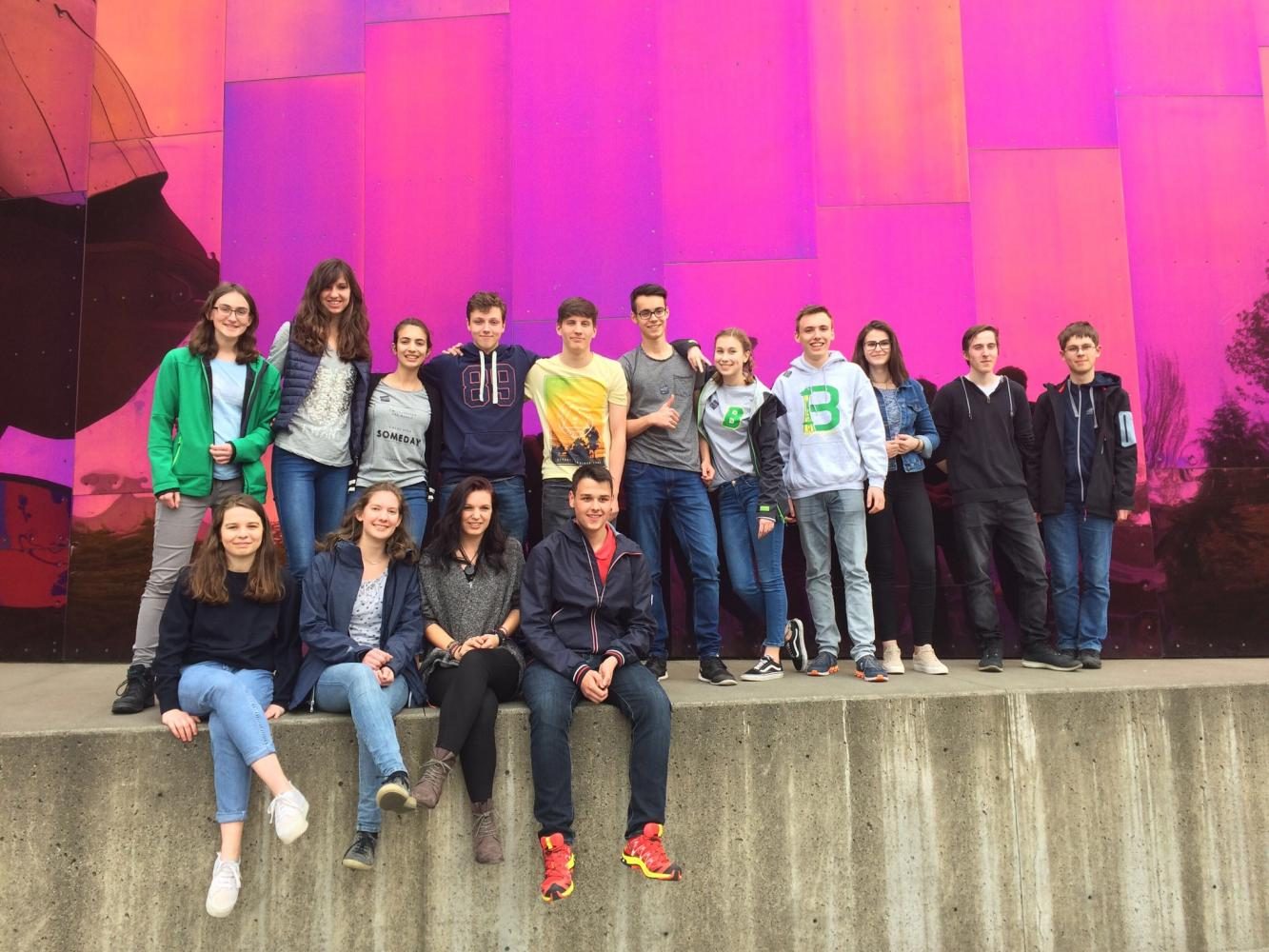 The students stand and sit in front of the MoPOP (formerly the EMP).