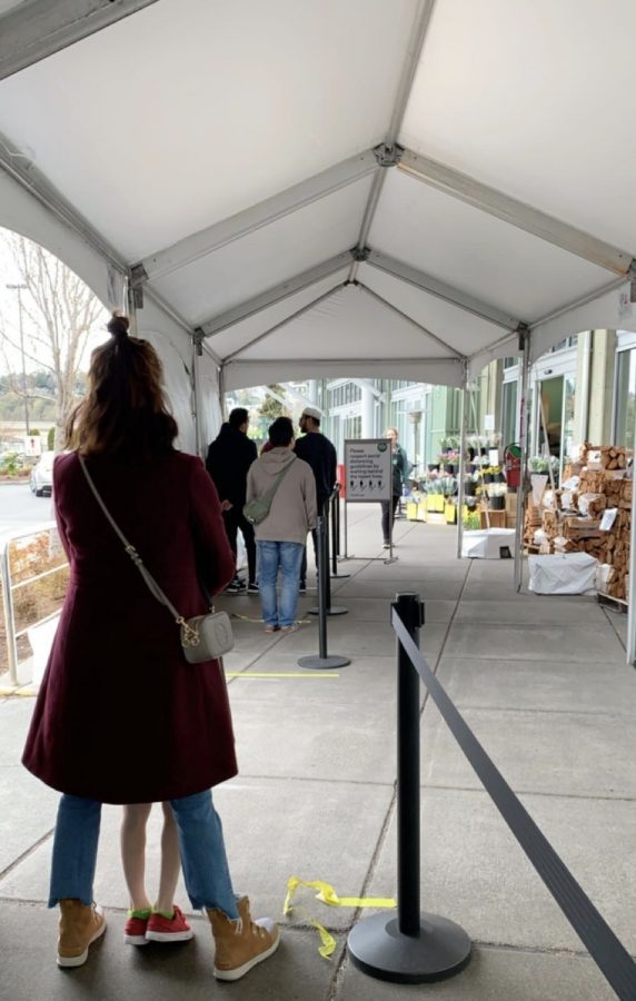 Customers standing six feet apart in line because of new rules of limited number allowed inside stores. 