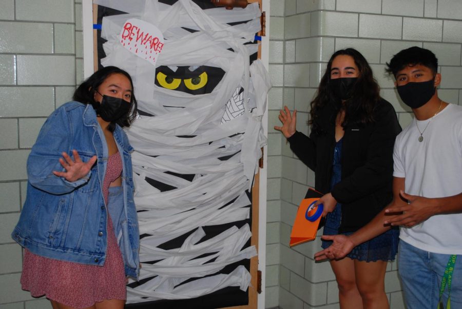 Juniors Becca Maw, Hiilei Leong and Brendon Manzano stand by their mummified CPs door.