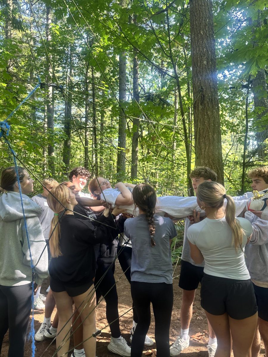 STICKING TOGETHER: Stella Scheifer trusts her classmates not to drop her during a Junior Retreat activity.
